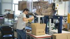 Ein Lagermitarbeiter, der Produkte verpackt.